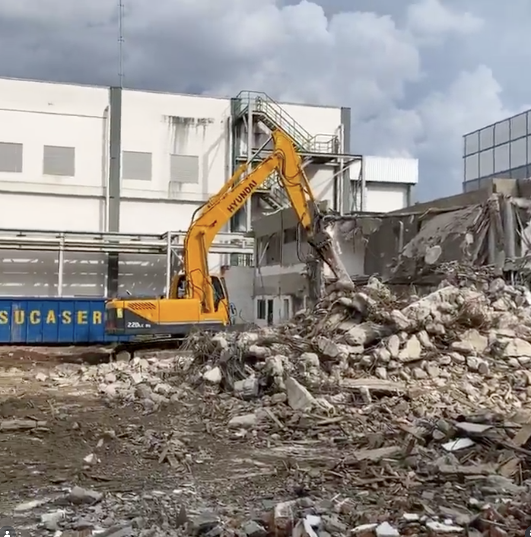Escavadeira em demolicao industrial